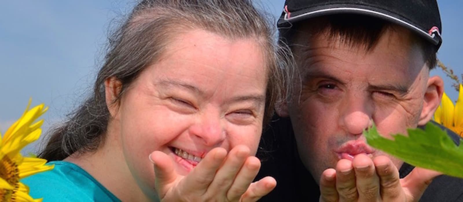Two people blowing a kiss