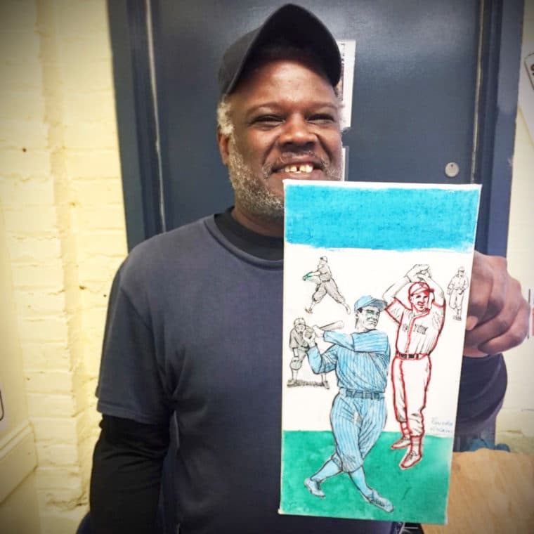 Artist Fausto Vizcaino holding a painting