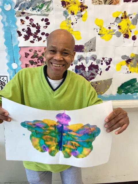 Photo of man holding up his artwork